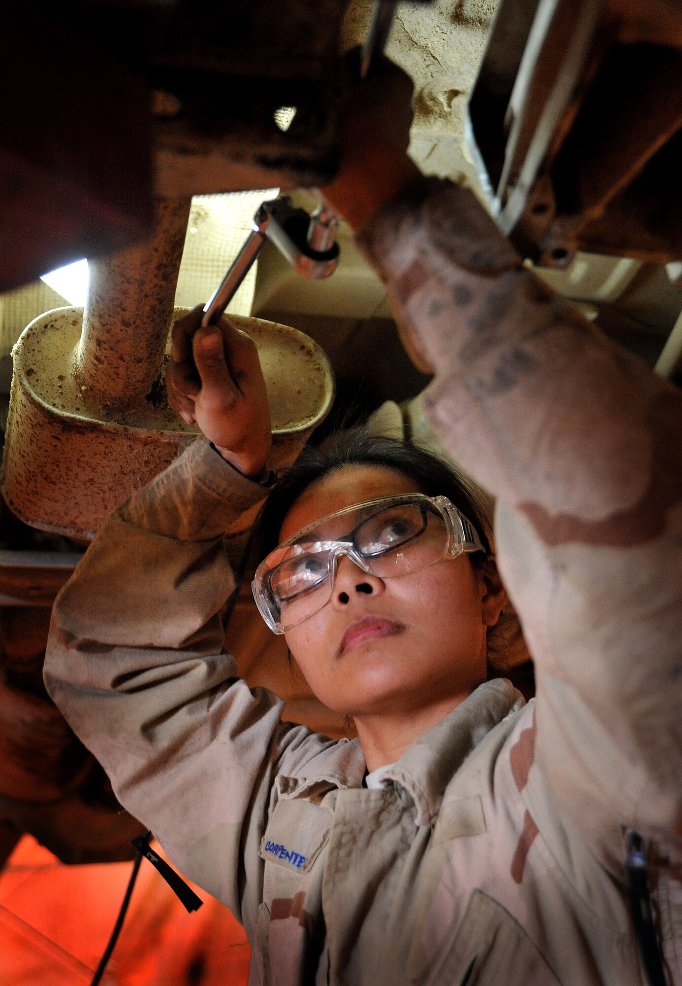 Senior Airman Catherine Carpenter, 407th Expeditionary Operations Support Squadron special purpose vehicle mechanic, works on a truck March 1, 2011, at Ali Air Base, Iraq. (U.S. Air Force photo by Senior Airman Andrew Lee/Released) 