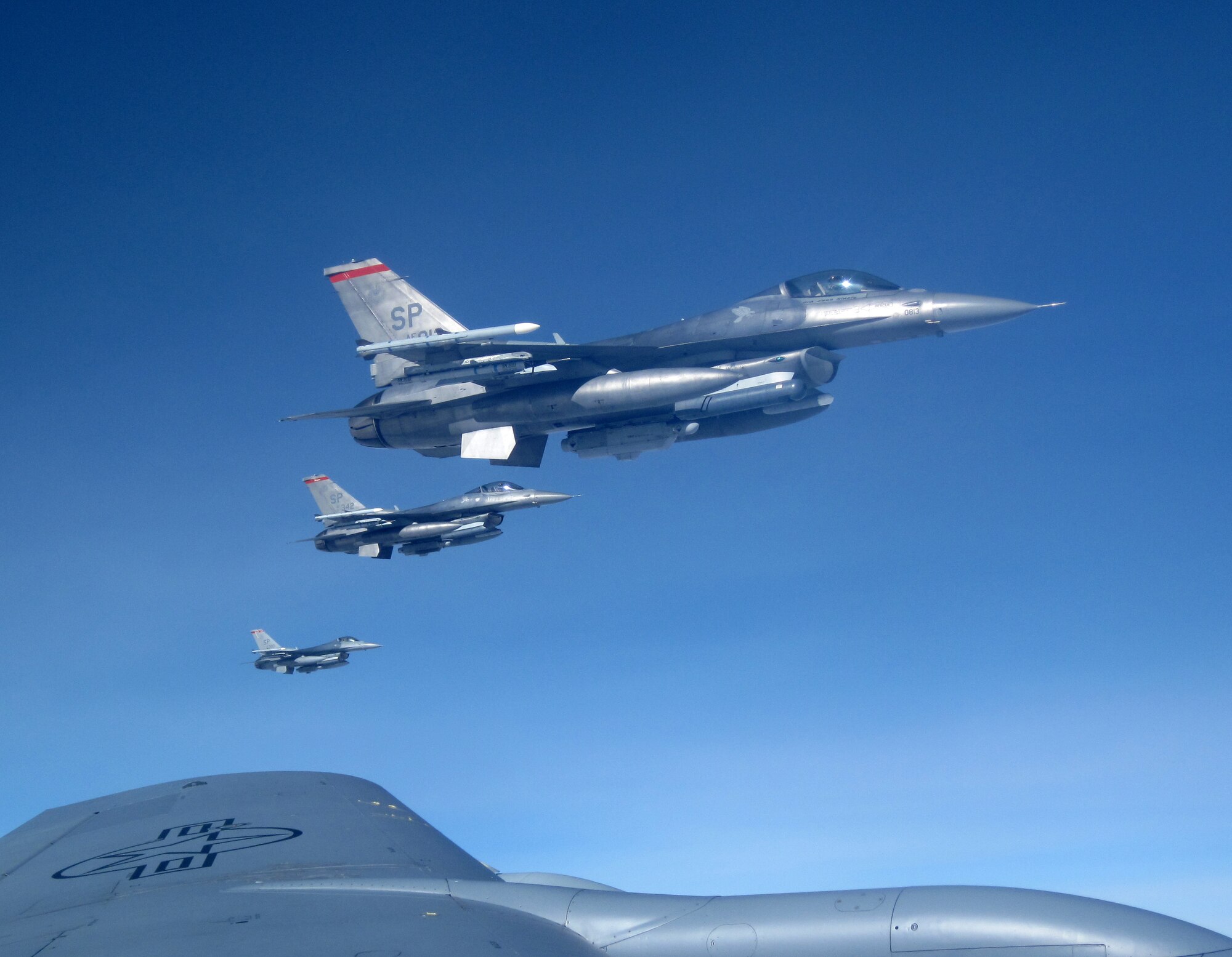 Three F-16 Fighting Falcon pilots from Spangdahlem Air Base, Germany, fly in formation off the wing tip of a 100th Air Refueling Wing KC-135 Stratotanker, as they await their turn to receive fuel, during a training mission over Germany, March 10, 2011. (U.S. Air Force photo/A1C Rachel Waller)