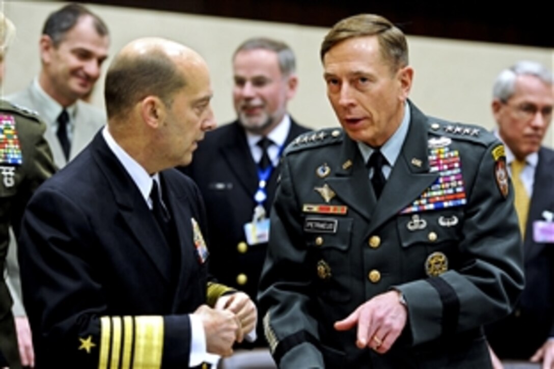 U.S. Army Gen. David H. Petraeus, right, commander of NATO and U.S. forces in Afghanistan, speaks with U.S. Navy Adm. James G. Stavridis, commander of European Command and NATO's supreme allied commander for Europe, at NATO headquarters in Brussels, Belgium, March 11, 2011.