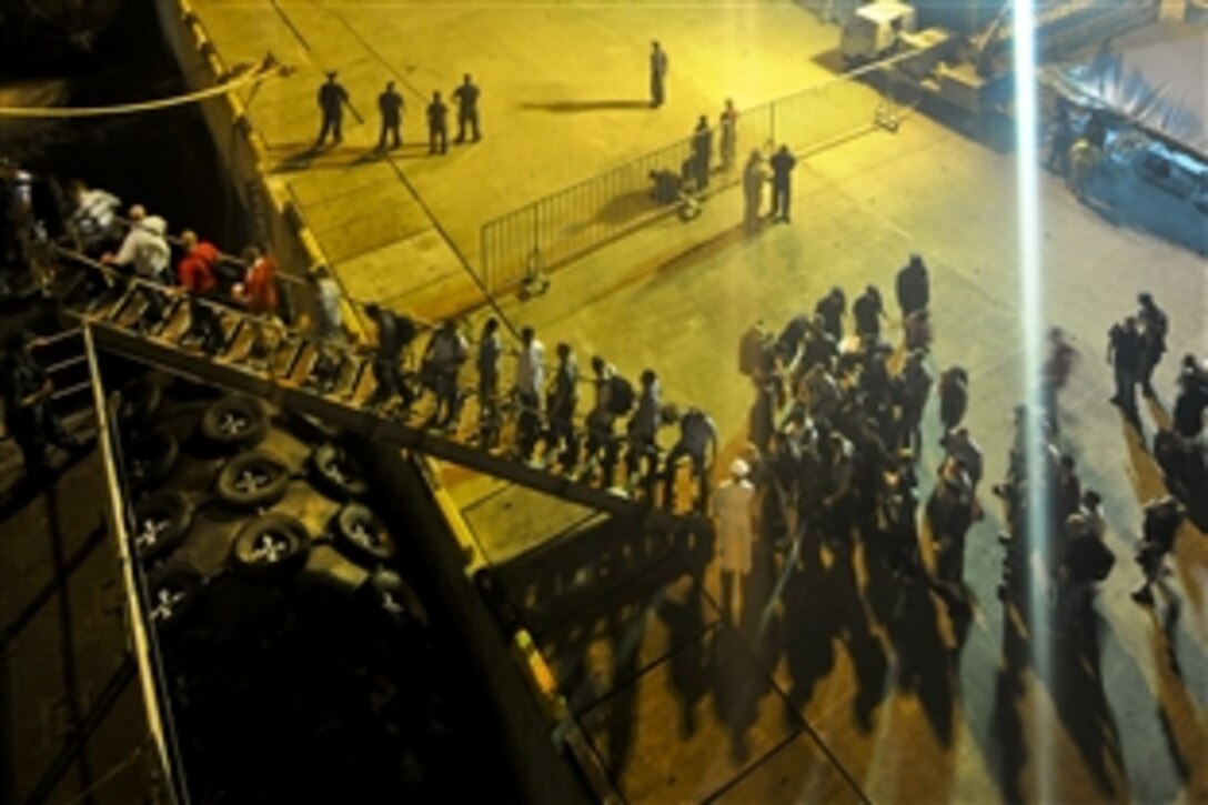 U.S. Navy sailors assigned to the amphibious assault ship USS Essex and Marines assigned to the 31st Marine Expeditionary Unit return to their ship at Sepangar Naval Base, Malaysia, March 11, 2011, to ensure the ship and crew are ready if directed to support earthquake and tsunami relief operations in Japan.