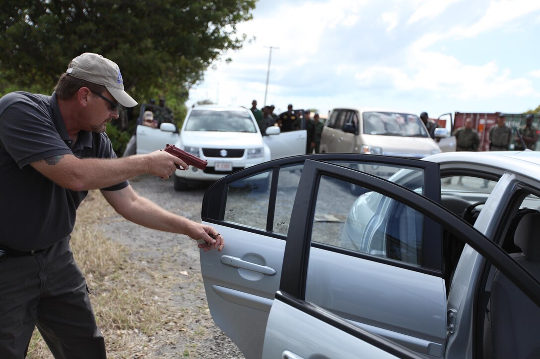 Naval Criminal Investigative Service Physical Security Specialist Thomas Krall demonstrates how to search a vehicle March 11 during exercise Tradewinds 2011.