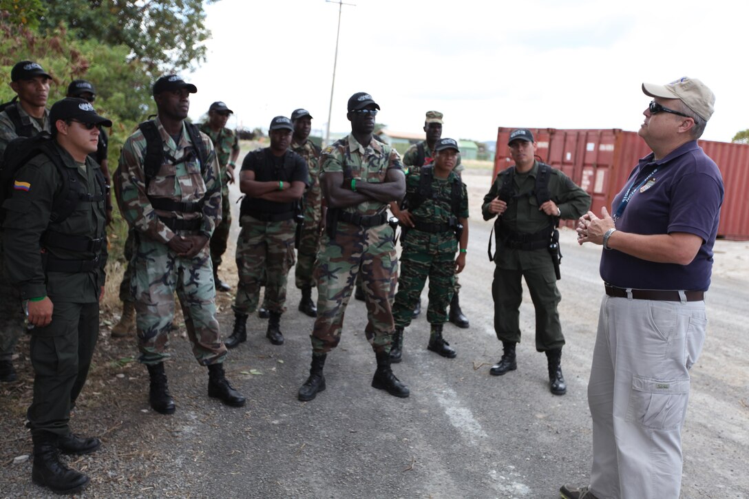 Naval Criminal Investigative Service Physical Security Specialist Randy Thomas offers guidance to Caribbean and South American civilian and military law enforcement personnel before conducting a mock vehicle search March 11 during exercise Tradewinds 2011.::r::::n::