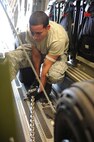 Airman 1st Class James Limon, 735th Air Mobility Squadron ramp service specialist, secures a generator to the floor of a C-17 in preparation for its departure on a  humanitarian mission to Japan Mar. 12 at Joint Base Pearl Harbor-Hickam, Hawaii. The plane will visit various Air Force bases in Japan during its mission to to provide support for Japan relief efforts in the wake of tsunami and earthquake damage there. (U.S. Air Force photo by Staff Sgt. Nathan Allen)