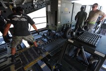 735th Air Mobility Squadron ramp service specialists and 535th Airlift Squadron loadmasters load generators onto a C-17 in preparation for its departure on a  humanitarian mission to Japan Mar. 12 at Joint Base Pearl Harbor-Hickam, Hawaii. The plane will visit various Air Force bases in Japan during its mission to to provide support for Japan relief efforts in the wake of tsunami and earthquake damage there. (U.S. Air Force photo by Staff Sgt. Nathan Allen)