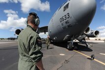 Tech. Sgt. Andrew Dunn, 15th Aircraft Maintenance Squadron crew chief, conducts a pre-flight maintenance inspection before departing on a  humanitarian mission to Japan Mar. 12 at Joint Base Pearl Harbor-Hickam, Hawaii. The plane will visit various Air Force bases in Japan during its mission to to provide support for Japan relief efforts in the wake of tsunami and earthquake damage there. (U.S. Air Force photo by Staff Sgt. Nathan Allen)