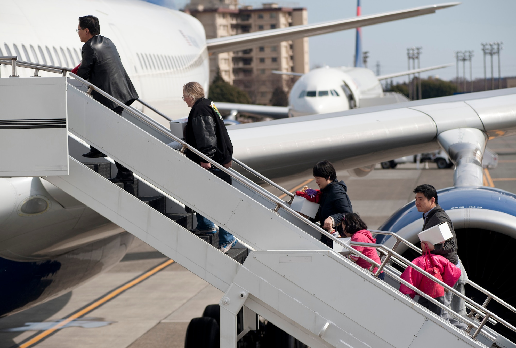 YOKOTA AIR BASE, Japan -- Passengers board two Delta Air Lines aircraft here March 12. The aircraft diverted to Yokota from Narita International Airport in Tokyo, Japan, after an 8.9 magnitude earthquake struck off the eastern coast of Japan. (U.S. Air Force photo/Staff Sgt. Samuel Morse)