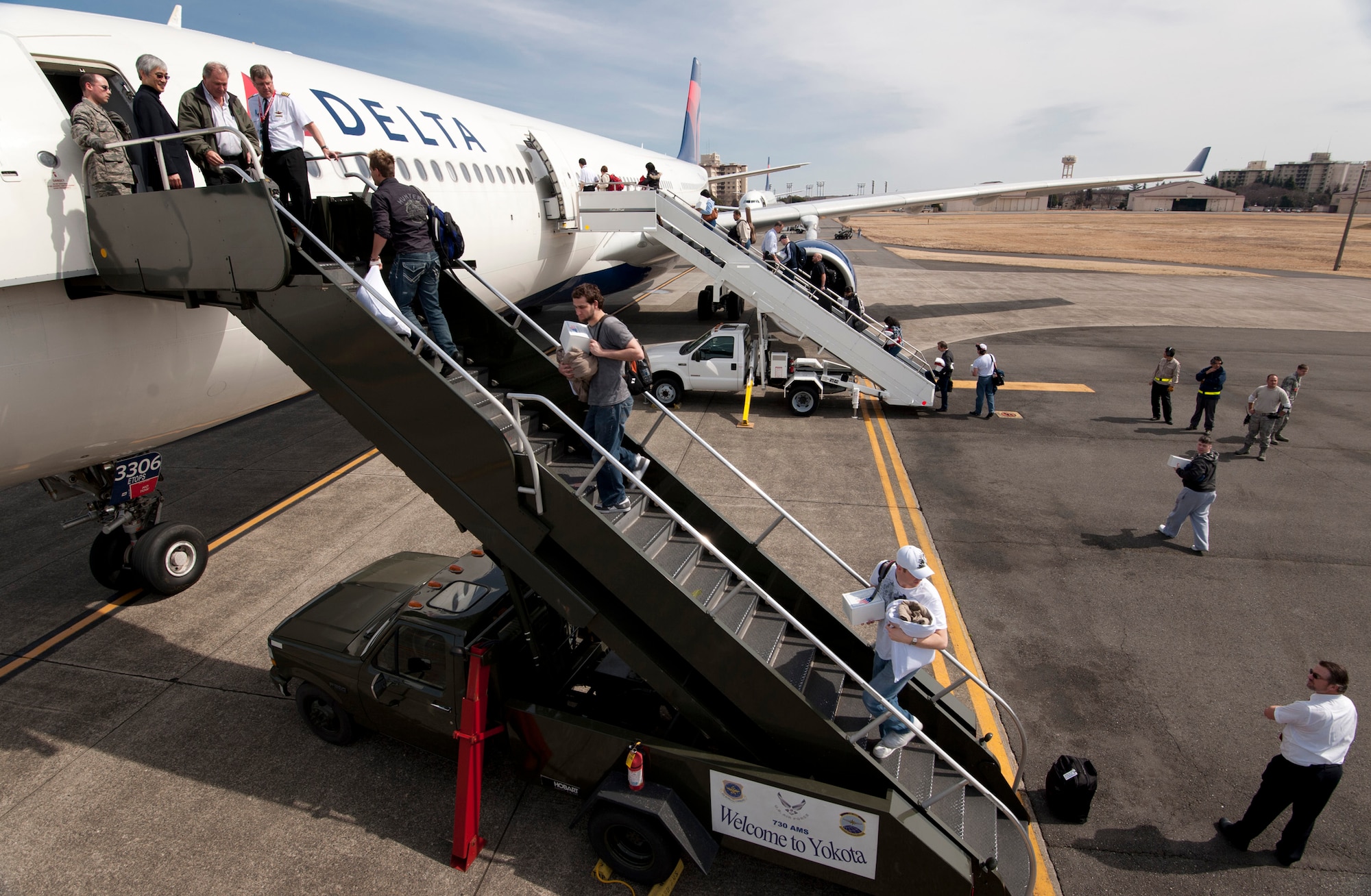 YOKOTA AIR BASE, Japan -- Passengers board a Delta Air Lines aircraft here March 12. The aircraft were diverted to Yokota from Narita International Airport in Tokyo, Japan, the day prior, after an 8.9 magnitude earthquake struck off the eastern coast of Japan. (U.S. Air Force photo by Staff Sgt. Samuel Morse)