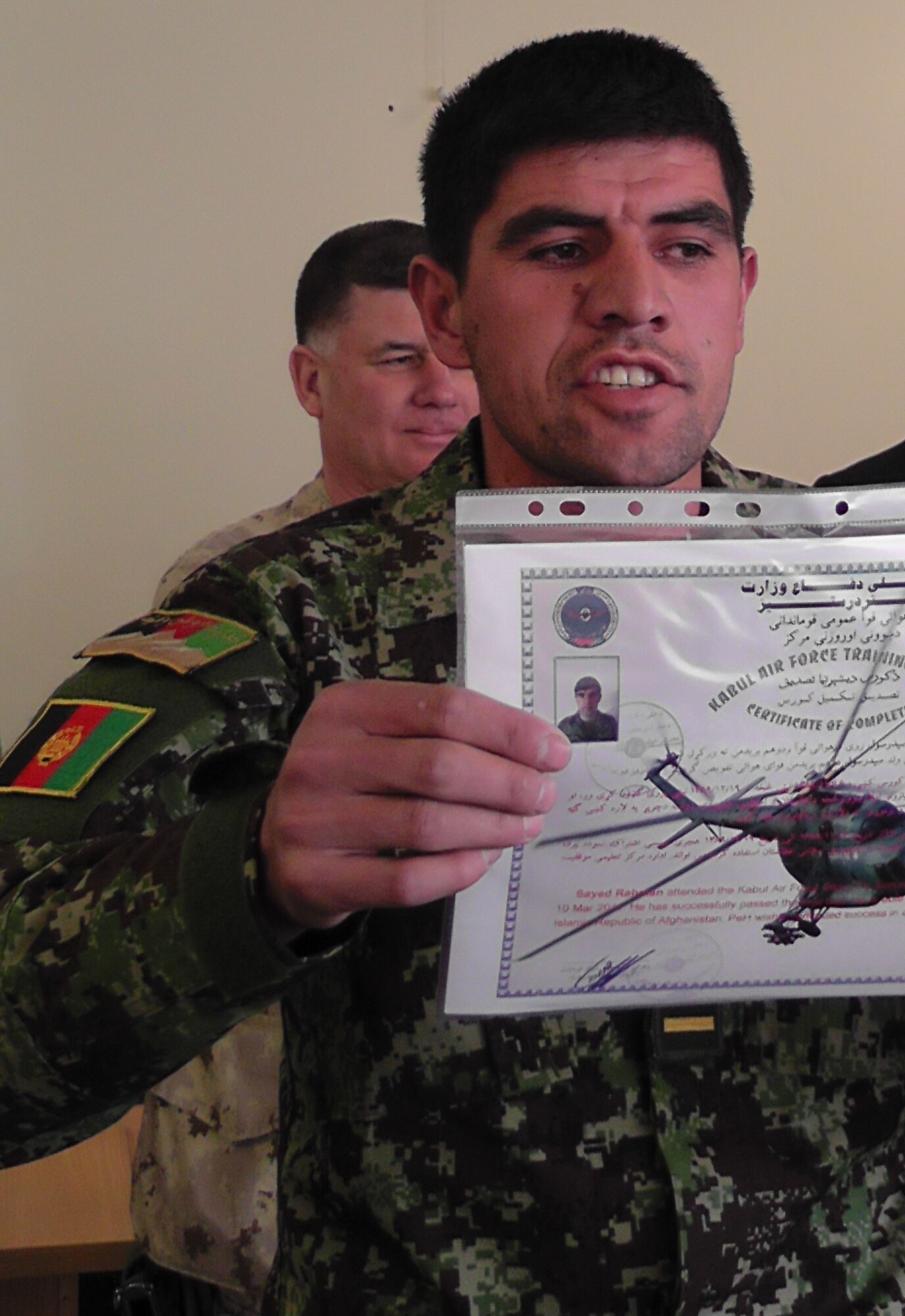 KABUL, Afghanistan - A member of the Afghan Air Force proudly presents his graduation certificate to the audience after graduating from the pre-undergraduate flight indoctrination at Pohantoon-e-Hawayee, the Afghan Air Force's "Big Air School", on the Afghan Air Force base in Kabul, Afghanistan Mar. 10. (U.S. Air Force photo by Capt. Rob Leese)