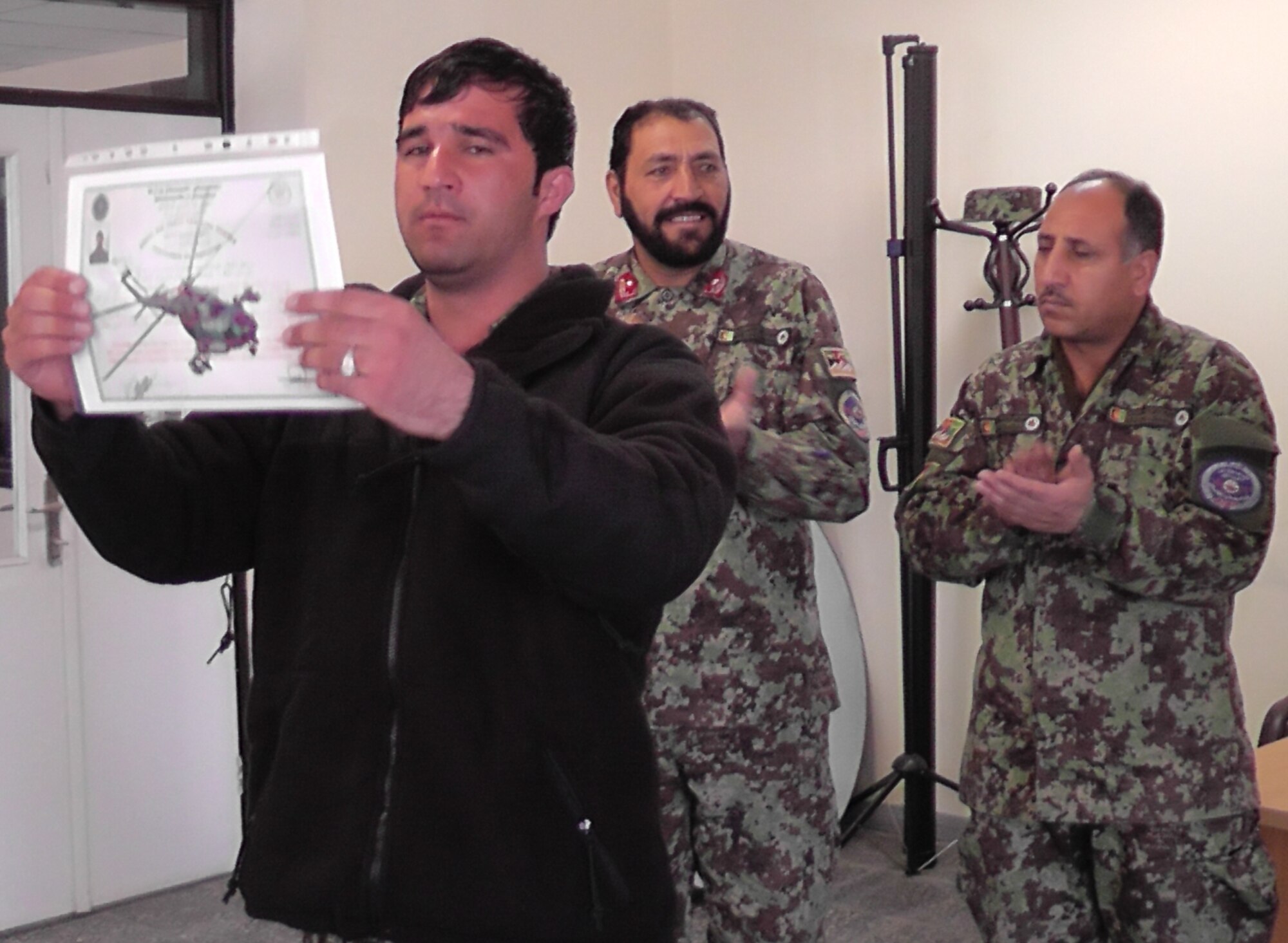 KABUL, Afghanistan - A member of the Afghan Air Force proudly presents his graduation certificate to the audience after graduating from the pre-undergraduate flight indoctrination at Pohantoon-e-Hawayee, the Afghan Air Force's "Big Air School", on the Afghan Air Force base in Kabul, Afghanistan Mar. 10. (U.S. Air Force photo by Capt. Rob Leese)