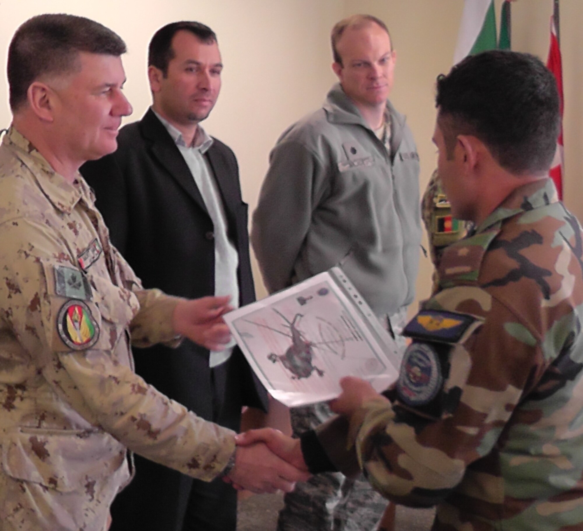 KABUL, Afghanistan - A member of the Afghan Air Force receives his graduation certificate after graduating from the pre-undergraduate flight indoctrination at Pohantoon-e-Hawayee, the Afghan Air Force's "Big Air School", on the Afghan Air Force base in Kabul, Afghanistan Mar. 10. (U.S. Air Force photo by Capt. Rob Leese)