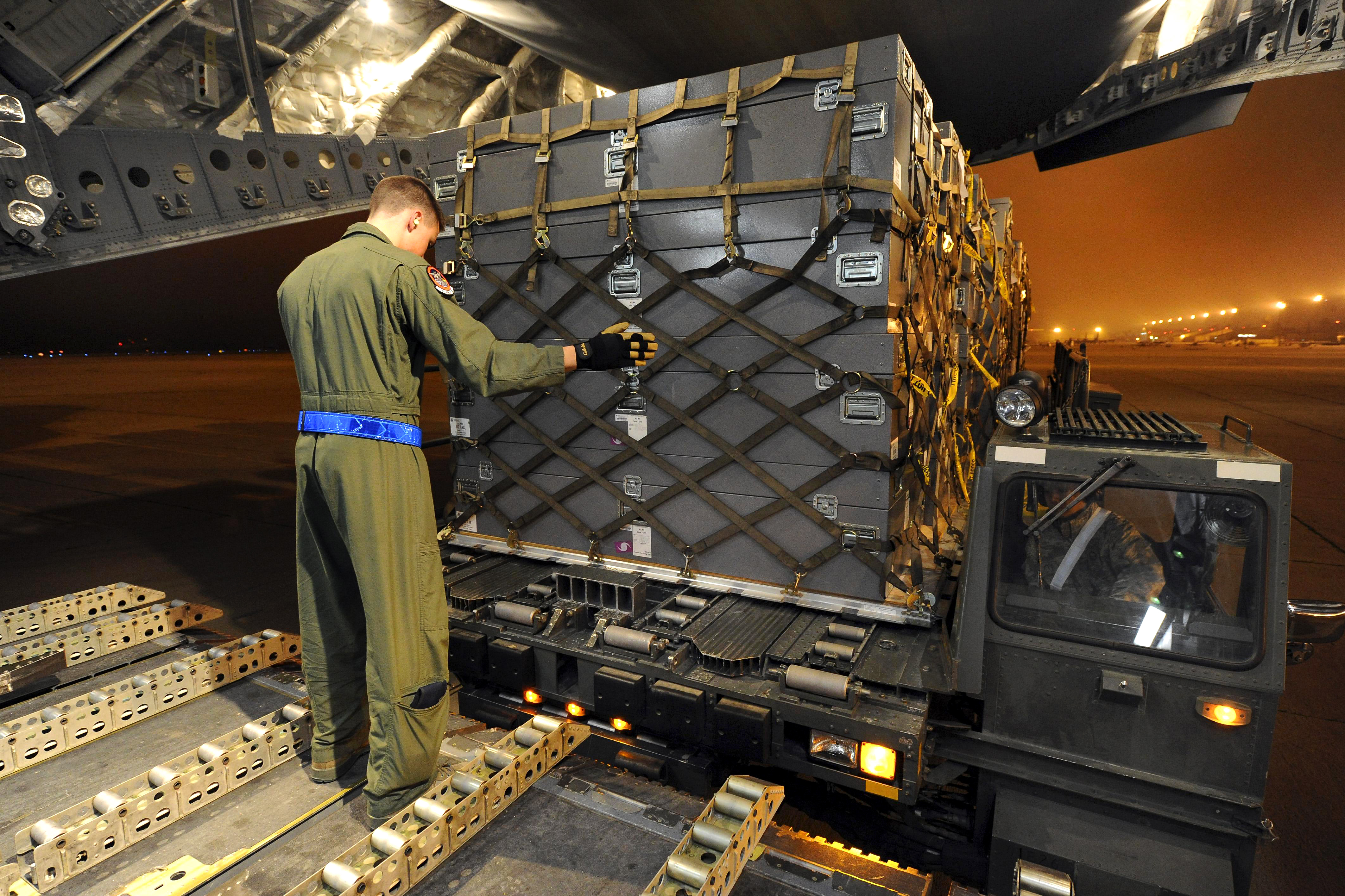 U.S. Air Force Airman 1st Class David Schmitz guides a Tunner 60K