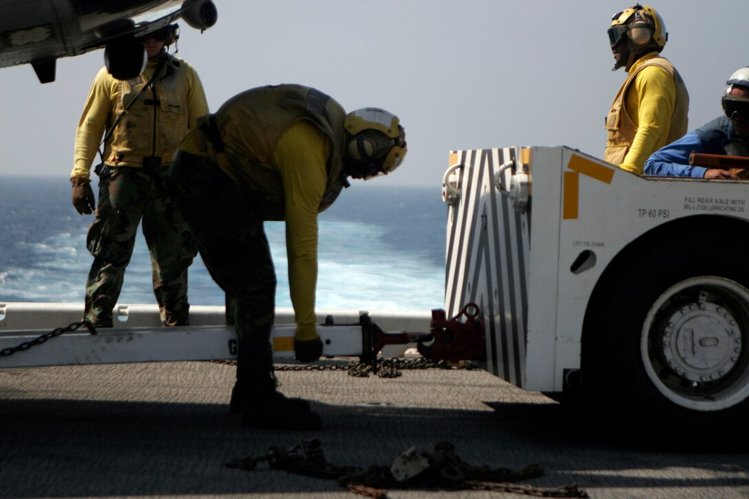 Sailors with Amphibious Squadron 11 attach a tow to a CH-46E Sea Knight helicopter with Marine Medium Helicopter Squadron 262 (Reinforced), 31st Marine Expeditionary Unit, during flight deck operations, March 13. Marines and sailors of the 31st MEU aboard the USS Essex (LHD 2) are making preparations for potential humanitarian assistance and disaster relief efforts after an 8.9 earthquake and subsequent tsunami struck Japan causing widespread damage. The USS Essex and 31st MEU are heading for the northeast coast of Japan to be ready to support to our friends and allies in their ongoing efforts and to be near enough to provide that support if called upon.