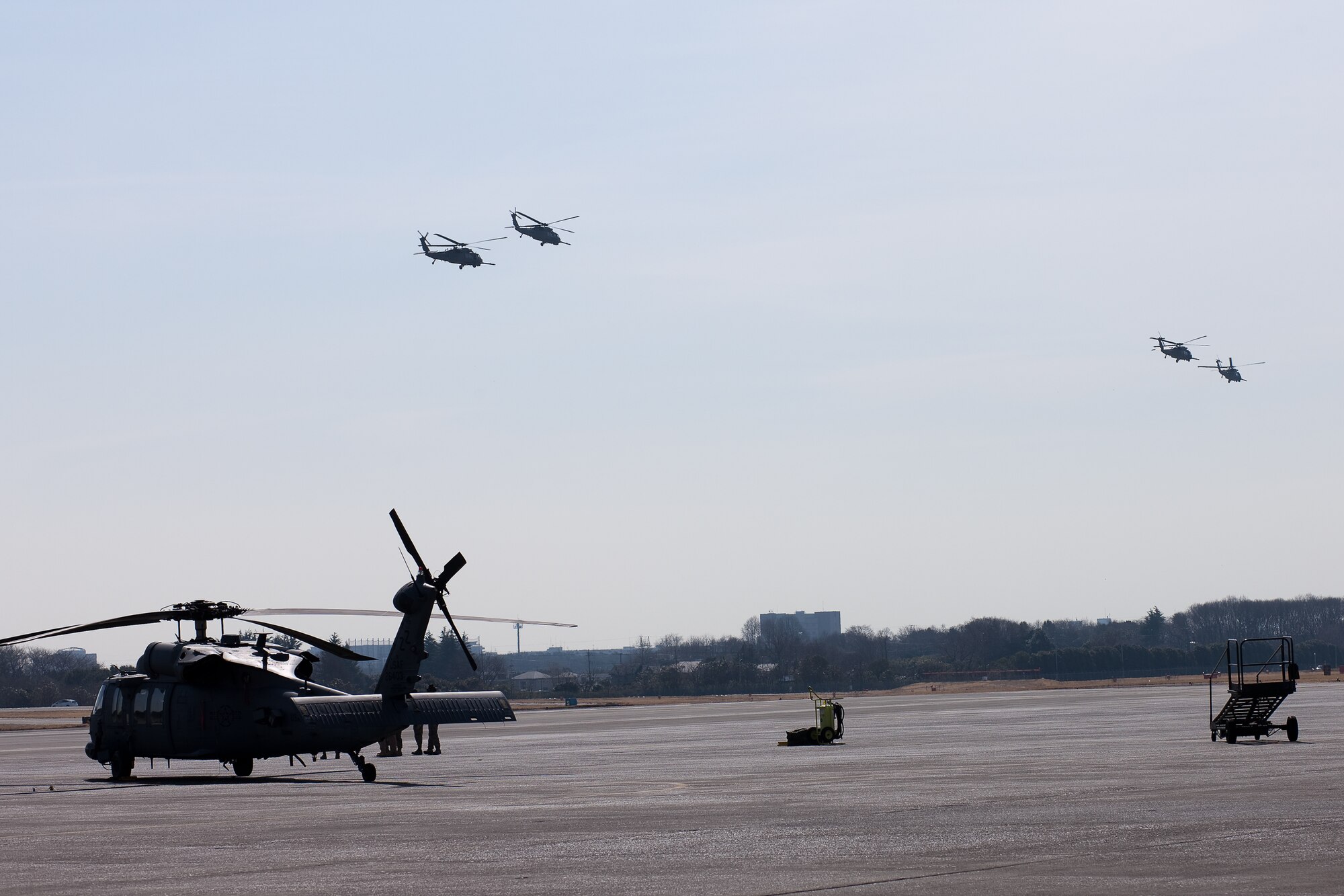 YOKOTA AIR BASE, Japan -- A joint team of Air Force and Marine search and rescue members board an HH-60 Pave Hawk helicopter here to participate in rescue missions March 14. Yokota is receiving personnel, aircraft and supplies to support search and rescue efforts as requested by the government of Japan. (U.S. Air Force photo/Osakabe Yasuo)