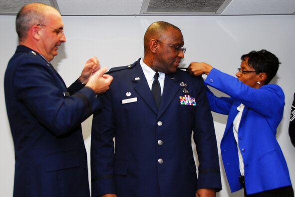 Col. Marshall Irvin, 403rd Mission Support Group commander, stands as his sister, Eunice, and Brig. Gen. James Muscatell, 403rd Wing commander pin on his new rank. Colonel Irvin was joined by his family and friends to celebrate the promotion at the Bay Breeze Event Center, Keesler Air Force Base, Miss.  (U.S. Air Force photo by Senior Airman Tabitha Dupas)

