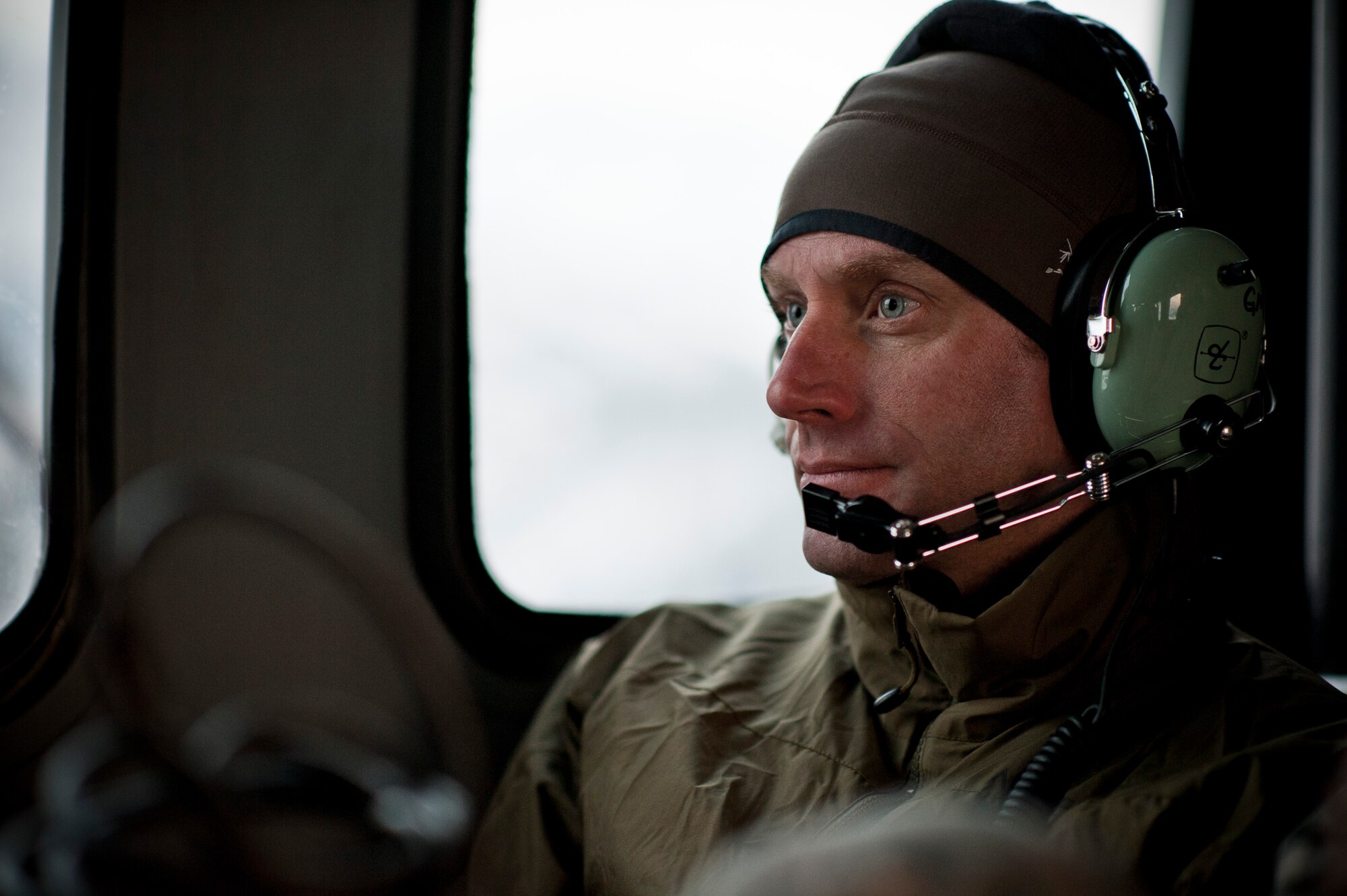 YAMAGATA, Japan -- Lt. Col. Steve Goodman, 31st Rescue Squadron commander, looks out from an HH-60 Pave Hawk helicopter for potential airfields here March 13. A joint team of U.S. Air Force and Marine personnel went on a survey mission to find staging points to store and reload fuel closer to the affected areas. (U.S. Air Force photo/Staff Sgt. Samuel Morse)