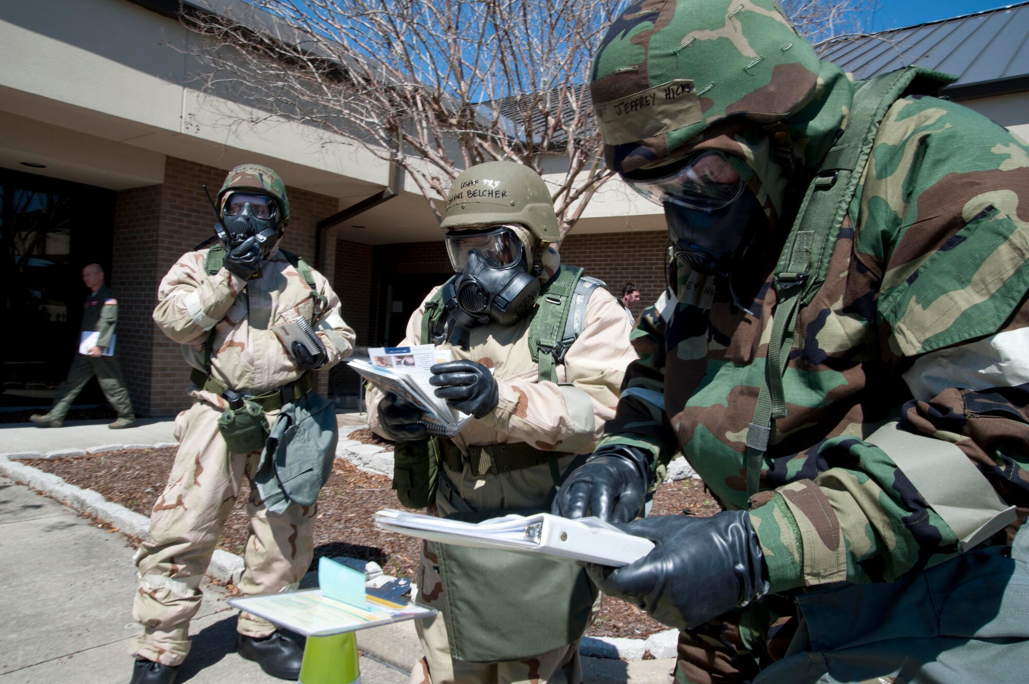 Capts. Jeffrey Hicks and Todd Humphries, 815th Airlift Squadron pilots, and Tech. Sgt. Shari Belcher, 403rd Aeromedical Staging Squadron medical technician, check M-8 paper at a Liquid Detection Point after a simulated attack to identify possible chemical agents. As member of the Post-Attack Reconnaissance Team, the Citizen Airmen swept the area around the 815th AS building for signs of damage, chemical agents, unexploded ordnance, and casualties. This is part of their training for the 403rd Wing’s upcoming Operational Readiness Inspection. (U.S. Air Force photo by Tech. Sgt. Ryan Labadens)