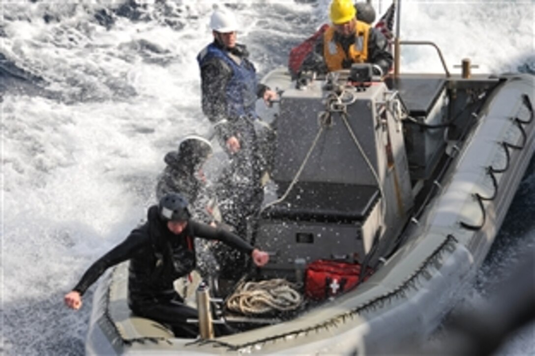 U.S. sailors steer their rigid-hull inflatable boat alongside the guided-missile destroyer USS John S. McCain after investigating several Japanese boats that appeared to be adrift after the recent earthquake and tsunami in the Pacific Ocean, March 13, 2011. The sailors are assigned to the McCain. 