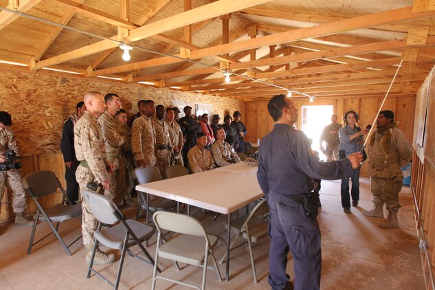 Marines with 3rd Battalion, 1st Marine Regiment, and role players acting as local army and police forces listen to a mission brief during the final week of an Advisor Training Group course March 14, 2011.