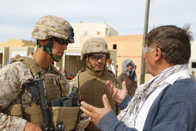 A Marine, with 3rd Battalion, 1st Marine Regiment, listens to the complaints of one of the role players through a translator during the final week of the Advisor Training Group course March 14, 2011.