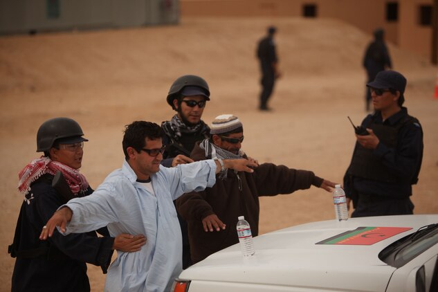 Afghan National Army role players search civilian role players during an exercise at Combat Center Range 220 March 14, 2011.
