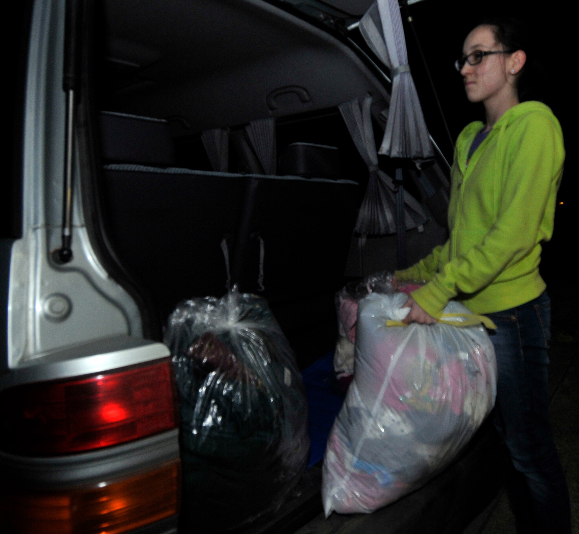 MISAWA AIR BASE, Japan -- Katie O’Czopek, daughter of Mark O’Czopek government contractor, removes bags of clothing donations from her father’s van Mar. 14. Edgren High School was collecting donations for the Misawa City community. (U.S. Air Force photo by Tech. Sgt. Phillip Butterfield\Released)