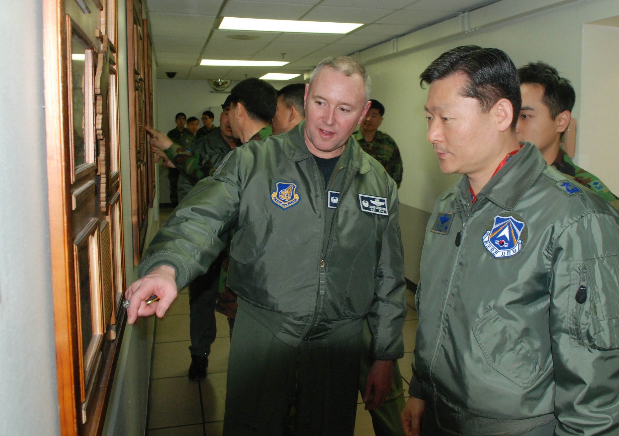 Col. James McGovern, U.S. Air Force 607th Air and Space Operations Center commander and Gen. Won, In Choul, Air Operations Center Director for the Republic of Korea Air Forces discuss Korean War critical events displayed on seven wooden panels after a dedication ceremony March 10, 2011, at Osan Air Force Base, Republic of Korea. 