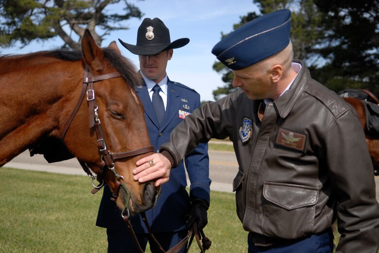 Col. Richard Boltz, the 30th Space Wing commander, meets military working horse Judge and his handler 2nd. Lt. Joshua Trayers, of the 30th Security Forces Squadron, during his retirement ceremony at Missile V here Monday, March 14, 2011. Military working horses Willy and Judge retire after a combined 35 years in military service. (U.S. Air Force photo/1st. Lt. Ann Blodzinski)
