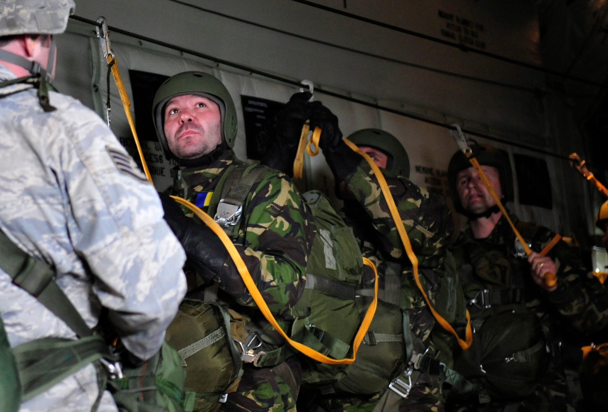 Romanian paratroopers prepare to exit a U.S. Air Force C-130J under the instruction of U.S. Air Force Staff Sgt. Joe Klimaski, 435th Contingency Response Group, jump master, over a landing zone near Campia Turzii, Romania, March 14, 2011.  The jump was performed on the first day of Carpathian Spring 2011, a building partnerships capacity exercise where members of the U.S. military join their Romanian counterparts to learn from one another and strengthen alliances. (U.S. Air Force Photo by Tech Sgt. Jocelyn L. Rich)