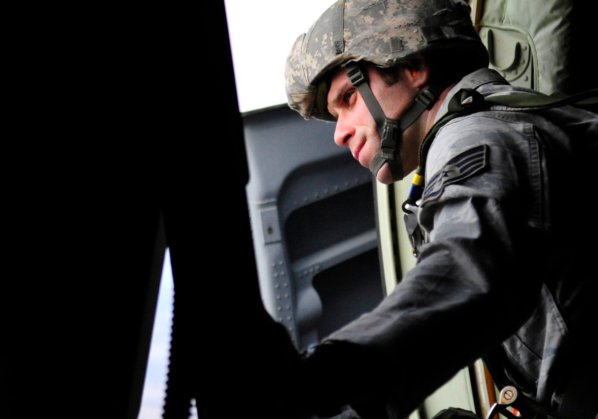 U.S. Air Force Staff Sgt. Joe Klimaski, 435th Contingency Response Group jump master, keeps watch out of the troop door of a U.S. Air Force C-130J, in preparation of a joint, static line jump with Romanian and U.S. paratroopers, over a landing zone near Campia Turzii, Romania, March 14, 2011. The jump was performed on the first day of Carpathian Spring 2011, a building partnerships capacity exercise where members of the U.S. military join their Romanian counterparts to learn from one another and strengthen alliances. (U.S. Air Force Photo by Tech Sgt. Jocelyn L. Rich).