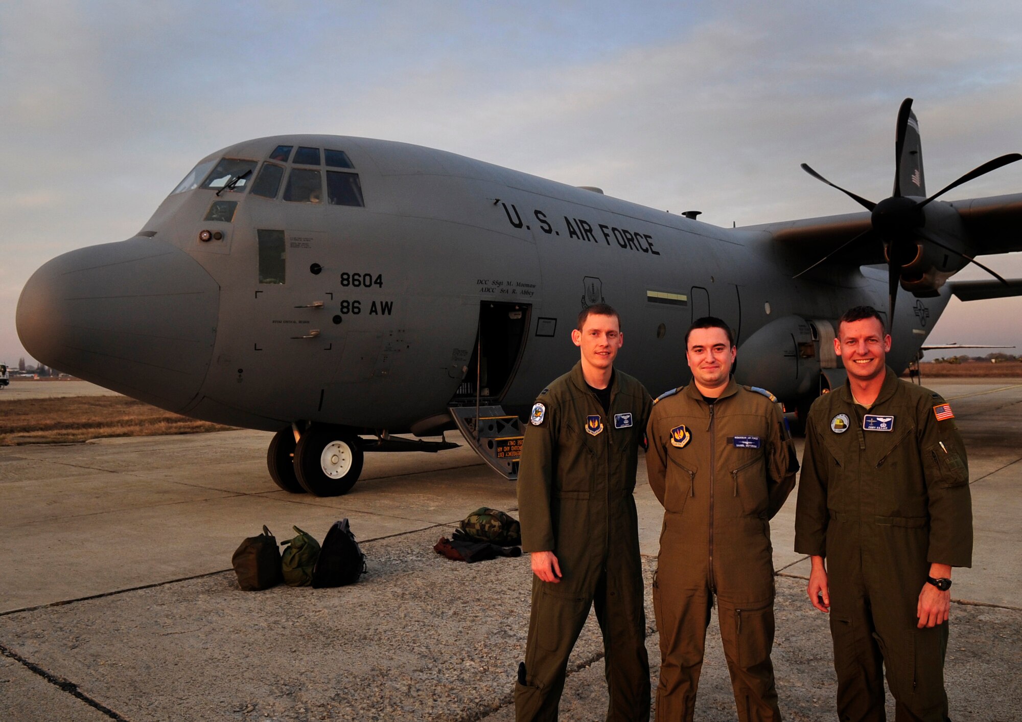 U.S. Air Force Capt. Justin Gripp (left) and 1st Lt. Cory Killian (right) both pilots from the 37th Airlift Squadron, pose with Romanian air force pilot Lt. Daniel Motoroiu (center), Airlift Base Otopeni, Romania, March 14, 2011. Lieutenant Motoroiu was invited to join the U.S. Air Force crew on their first flying mission of Carpathian Spring 2011, a building partnerships capacity exercise where members of the U.S. military join their Romanian counterparts to learn from one another and strengthen alliances. (U.S. Air Force Photo by Tech Sgt. Jocelyn L. Rich)