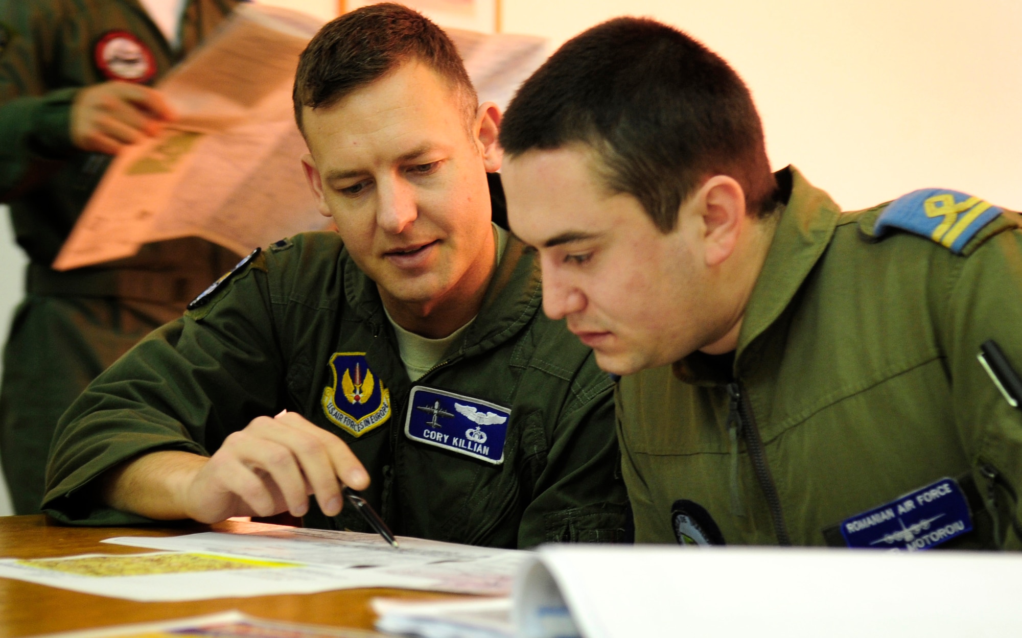 U.S. Air Force 1st Lt. Cory Killian, 37th Airlift Squadron pilot, reviews a flight plan with Romanian air force Lt. Daniel Motoroiu,pilot, during a pre-flight briefing, Airlift Base Otopeni, Romania, March 14, 2011. Lieutenant Daniel Motoroiu joined Lieutenant Killian and his crew on the first flying mission of Carpathian Spring 2011, a building partnership capacity exercise where members of the U.S. military join their Romanian counterparts to learn from one another and strengthen alliances. (U.S. Air Force Photo by Tech Sgt. Jocelyn L. Rich)
