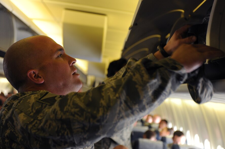 MOODY AIR FORCE BASE, Ga.-- Master Sgt. Richard Austin, 23rd Aircraft Maintenance Squadron specialist section chief, loads his bags in the over-head compartments of a commercial aircraft March 14. Members of the 23rd Maintenance Group boarded the aircraft in two groups of 50 members and one last large group of the remaining personnel. (U.S. Air Force photo/Airman 1st Class Benjamin Wiseman)(RELEASED)