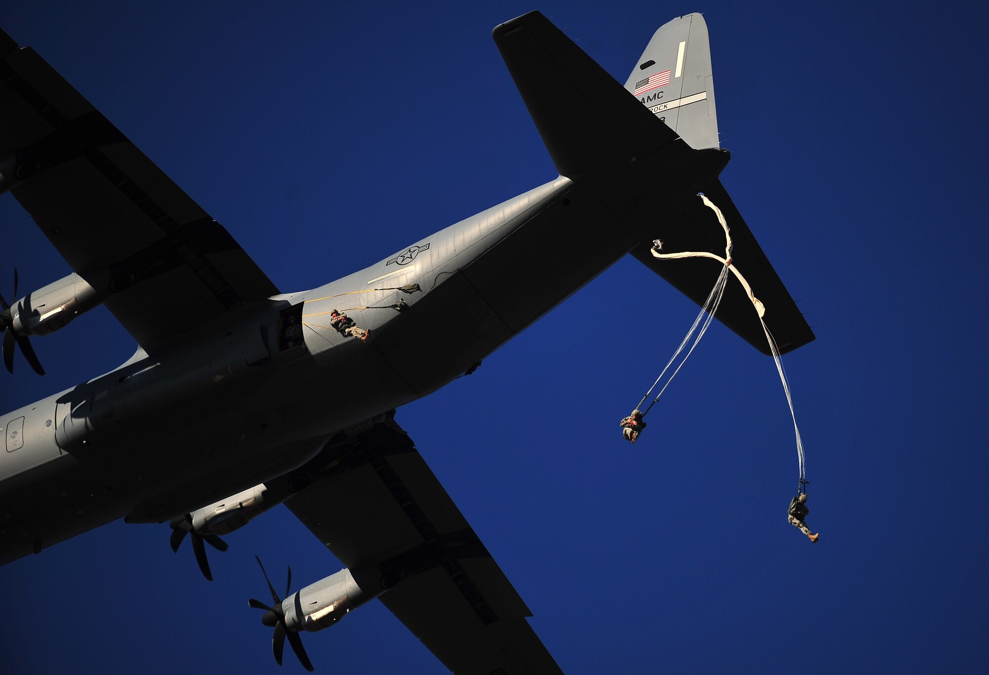 A C-130 Hercules drops U.S. Army Soldiers over Sicily Drop Zone at Ft. Bragg, Fayetteville, N.C., Feb. 12, 2011 for Large Package Week, during Joint Operational Access Exercise 11-01. Large Package Week/JOAX is an exercise that utilizes several Air Force C-130 and C-17 aircraft to strategically airdrop troops and cargo onto a specified location in preparation for real world contingency response. (U.S. Air Force photo/ Airman 1st Class Samuel W. Goodman)