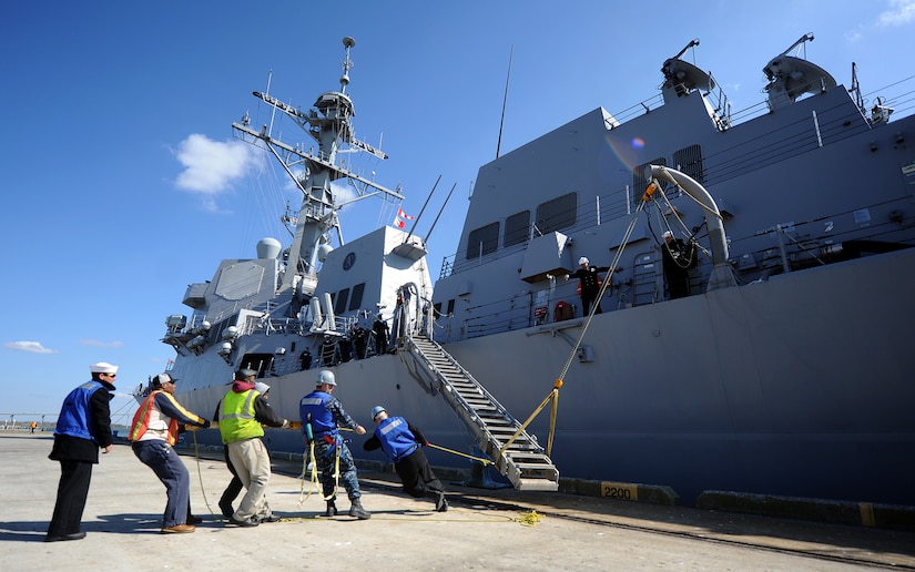 Sailors and civilian port workers/hands move the ships accomadation ladder into place at the Charleston Marina March 11, 2011 at Charleston, S.C. Farragut hosted Naval Reserve Officer Training Corps Midshipmen from the Citadel for a brief introduction to shipboard life. (U.S. Air Force photo/Senior Airman Timothy Taylor)