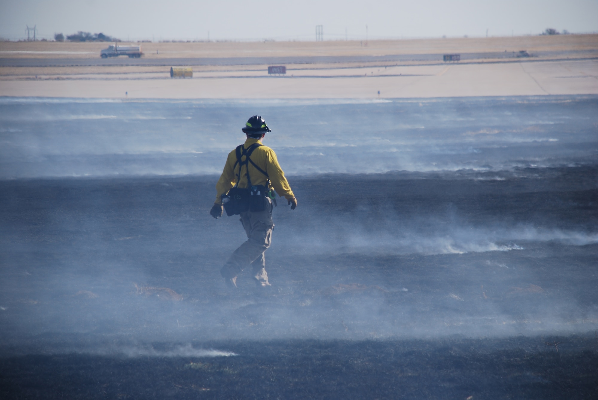 Kelly Carter, a Burkburnett, Texas, firefighter and burn boss checks his work March 12 following a controlled burn at Sheppard Air Force Base. A controlled burn was conducted to test its effect on mitigating the growth of various grasses and weeds as well as how it could control the wildlife that takes up residence on the flightline. (U.S. Air Force photo/John Ingle)