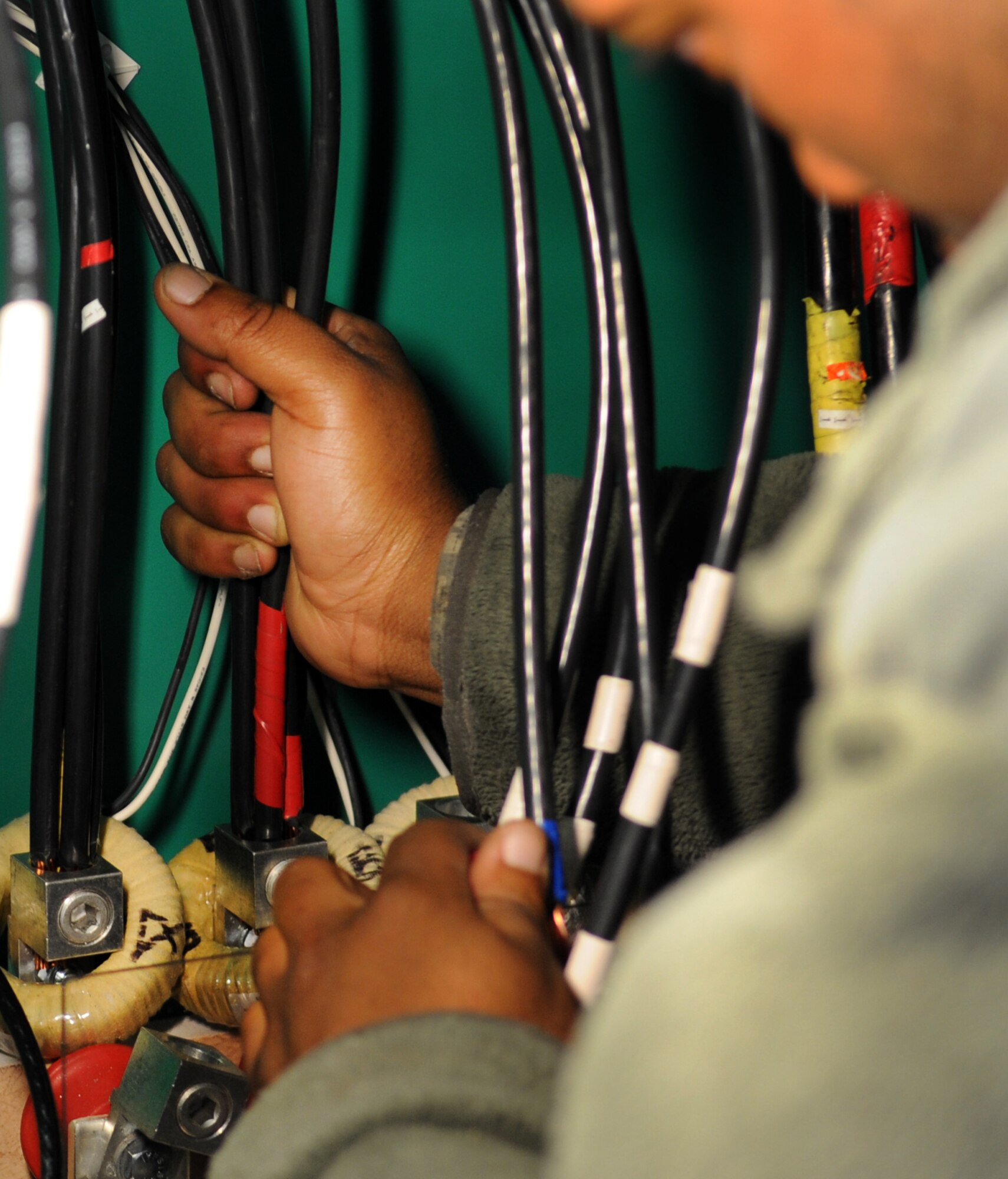 MOODY AIR FORCE BASE, Ga. -- Senior Airman Desmonn Comeaux, 23rd Civil Engineer Squadron electrical power production journeyman, connects electric cables to an automatic transfer switch March 12. To ensure a good connection, Airman Comeaux must hold the cables firmly in place while securing them. (U.S. Air Force photo/Airman 1st Class Douglas Ellis)(RELEASED)
