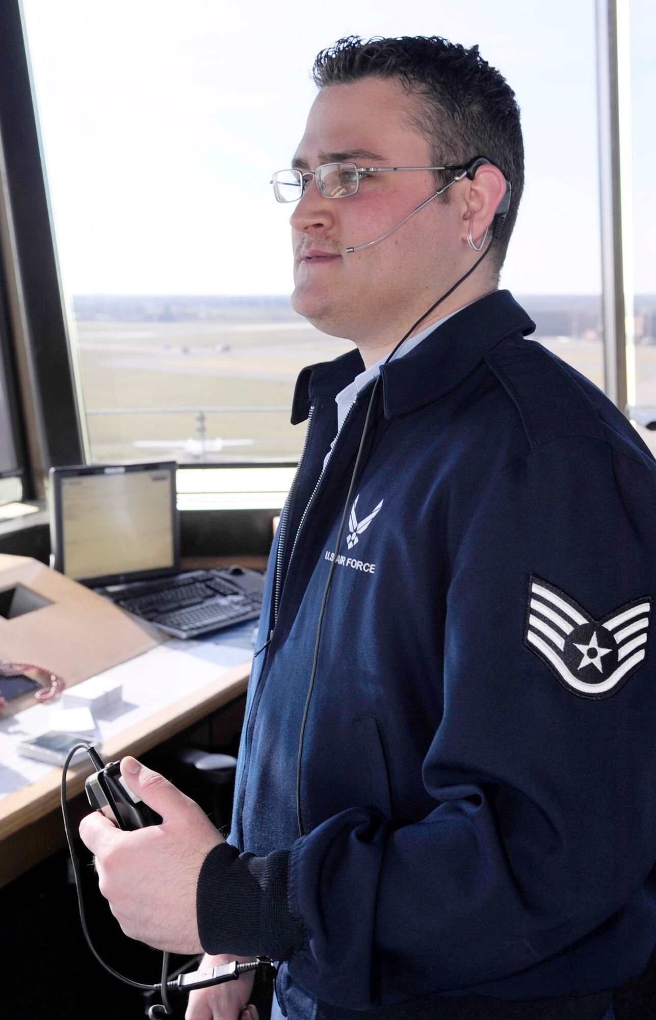 RAF MILDENHALL, England -- Staff Sgt. Joseph Pearcey, 100th Operations Support Squadron air traffic controller, clears an incoming plane for landing here March 14, 2011. The tower begins communication with all incoming aircraft 10 miles out and touches base with more than 19,000 aircraft annually. (U.S. Air Force photo/Senior Airman Ethan Morgan)