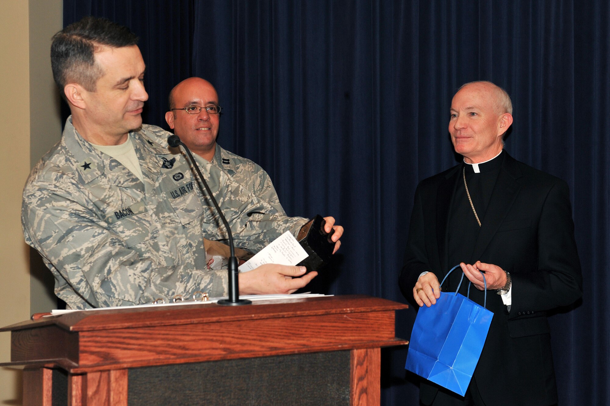 OFFUTT AIR FORCE BASE, Neb. - Brig. Gen. Donald Bacon, 55th Wing commander, presents a gift to George Lucas, Archbishop of Omaha, during the national prayer luncheon inside the Patriot Club March 10. Throughout this luncheon many of Offutt's personnel representing different faiths and backgrounds came together to pray for warriors fighting for our nation and our families. U.S. Air Force Photo by Charles Haymond