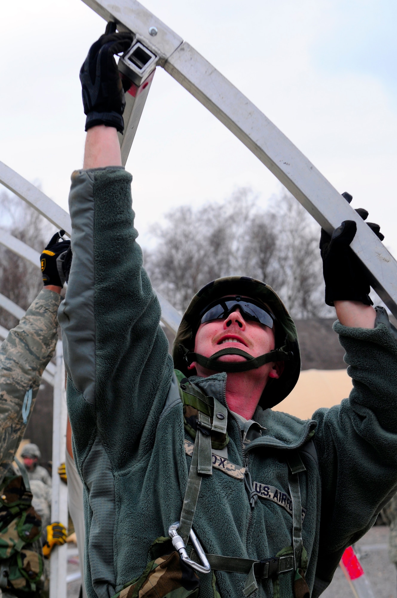 U.S. Air Force Staff Sgt. James Cox, 52nd Civil Engineer Squadron, helps erect a tent during the practical application exercise portion of Silver Flag, Ramstein Air Base, Germany, March 11, 2011. Silver Flag is a weeklong, training program that Airmen from all over the world participate in. Silver Flag combines classroom and practical application exercises to prepare airmen for deployment. (U.S. Air Force Photo by Airman 1st Class Brea Miller)