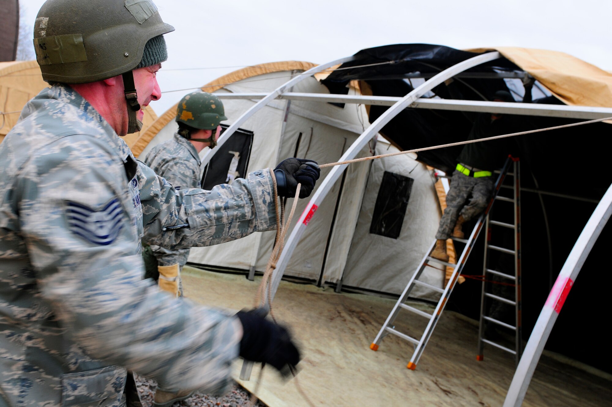 U.S. Air Force Tech. Sgt. Daniel Luning, 52nd Civil Engineer Squadron, helps erect a tent during the practical application exercise portion of Silver Flag, Ramstein Air Base, Germany, March 11, 2011. Silver Flag is a weeklong, training program that Airmen from all over the world participate in. Silver Flag combines classroom and practical application exercises to prepare airmen for deployment. (U.S. Air Force Photo by Airman 1st Class Brea Miller)