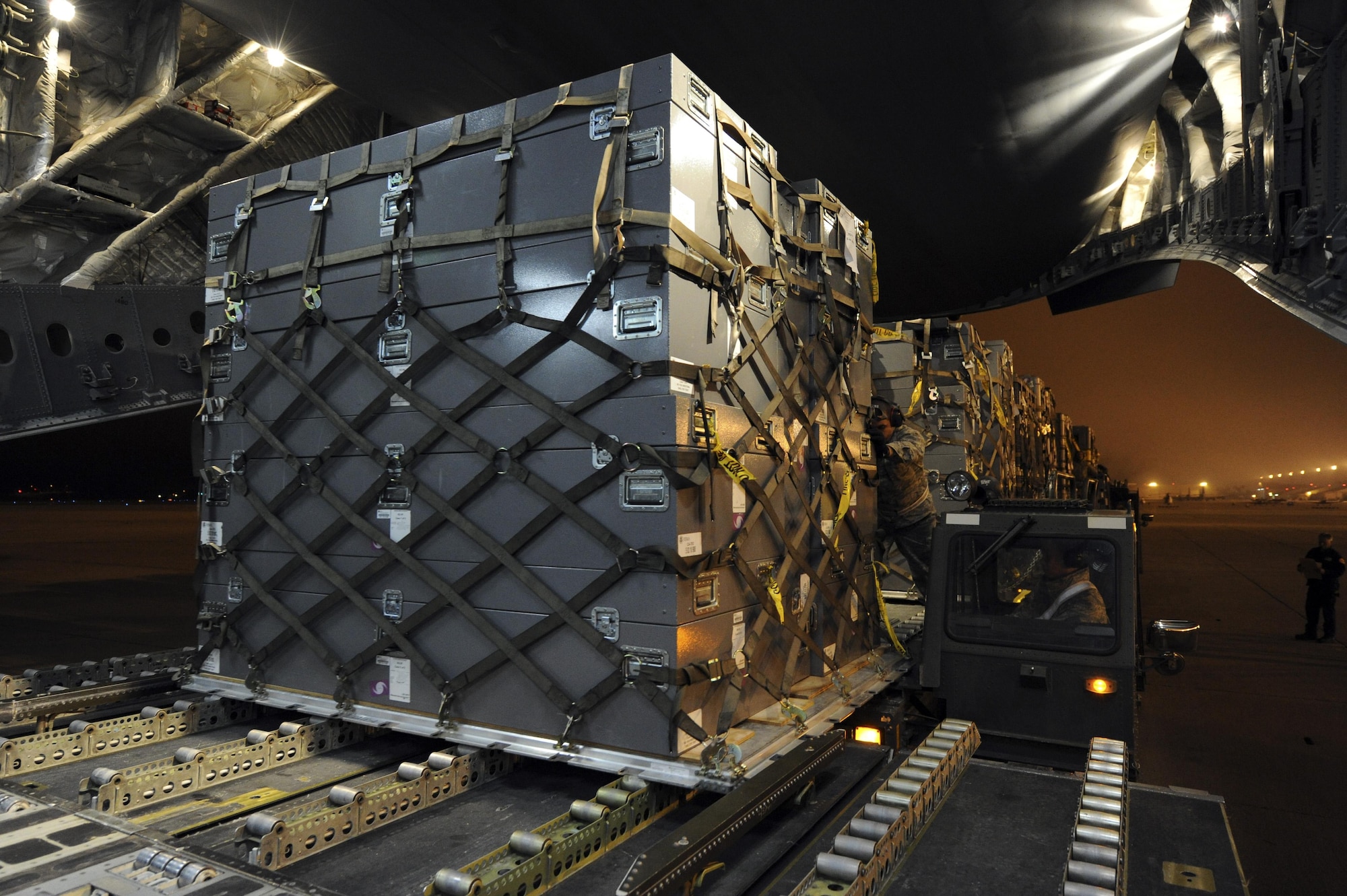 U.S. Air Force members unload a pallet from a Tunner 60K loader onto a U.S. Air Force C-17A Globe Master III, March 12, March Air Reserve Base, Calif. The supplies are in route to Japan for earthquake relief efforts. (U.S. Air Force photo by Staff Sgt. Matthew Smith/Released)