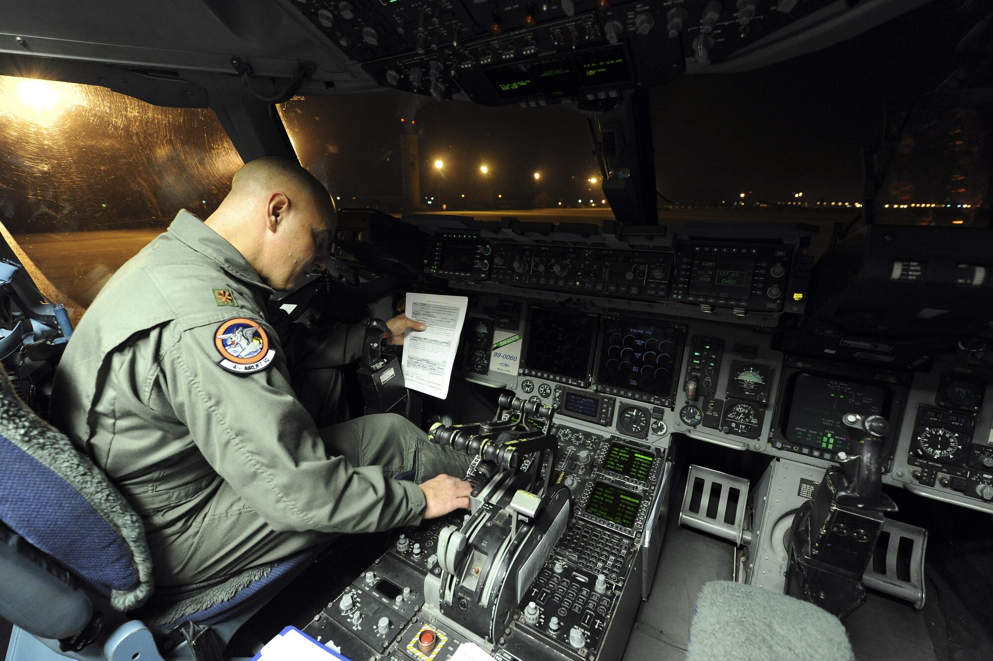 U.S. Air Force Maj. Todd Risk, 4th Airlift Squadron, Joint Base Lewis-McChord, Wash., inputs his flight plan into a U.S. Air Force  C-17A Globe Master III, March 12, March Air Reserve Base, Calif., in preparation for a flight to Japan to help with earthquake relief. (U.S. Air Force photo by Staff Sgt. Matthew Smith/Released)