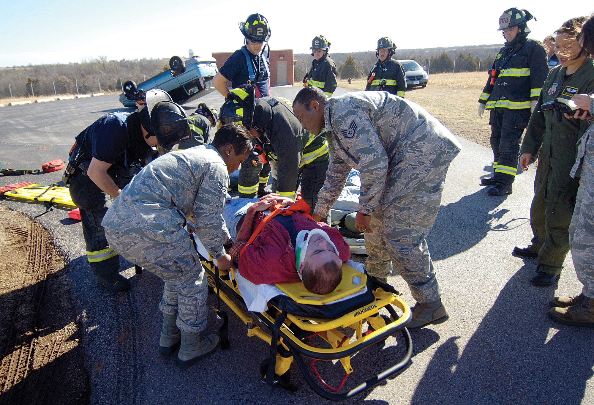 Tinker fire and medical personnel ready a mock victim for ambulance transport at the scene of a base tornado and munitions exercise March 1. This disaster exercise had responders dealing with a tornado hitting a munitions facility on Tinker, injuring people and spreading munitions in the destruction area. (Air Force photo by Margo Wright)
