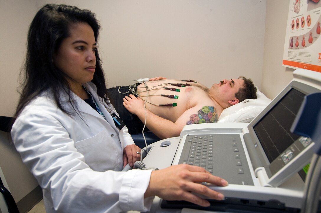 Lee Ann Quiroz, Navy Branch Health Clinic Naval Air Facility Washington radiographer, left, monitors Navy Intelligence specialist 3rd Class Kevin Houle, Office of Naval Intelligence, Suitland, Md., during an EKG test March 9. The Navy Branch Health Clinic’s services are available to all active duty servicemembers in building 3282 from 7 a.m. to 4 p.m., Monday through Friday. Open access sick call for active duty servicemembers is from 8 a.m. to 10 a.m. and from 1 p.m. to 2 p.m. The NBHC offers general dentistry, primary care and flight medicine services. (U.S. Air Force photo/Bobby Jones)