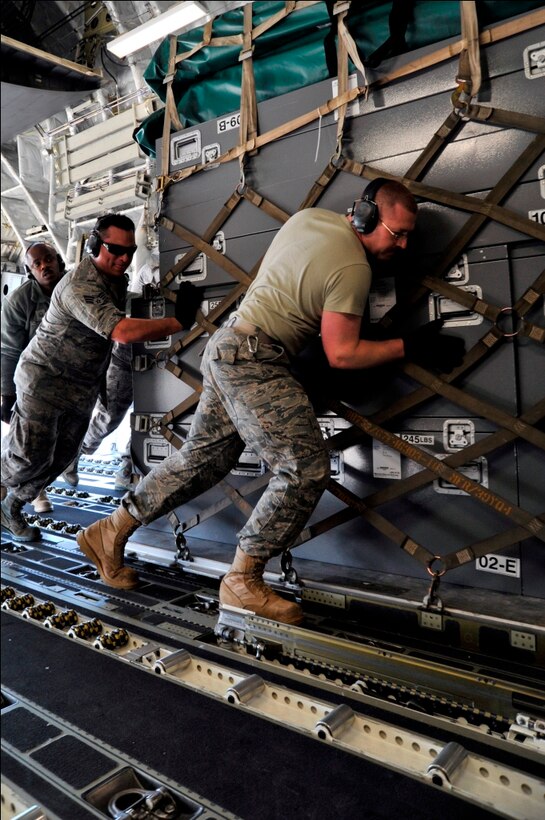 Airmen from the 89th Aerial Port Squadron load pallets onto a C-17 Globemaster III on March 12, 2011, at Joint Base Andrews, Md. Air transportation Airmen from the 89th APS created 14 pallets of technical search and rescue gear, to include inflatable swift-water rescue boats, generators, trench rescue and cutting equipment. The gear is being transported by C-17 to more than 80 Fairfax County Urban Search and Rescue technicians, to provide assistance in the rescue effort after an earthquake and tsunami hit Japan on March 11, 2011. (U.S. Air Force Photo/Senior Airman Perry Aston) 