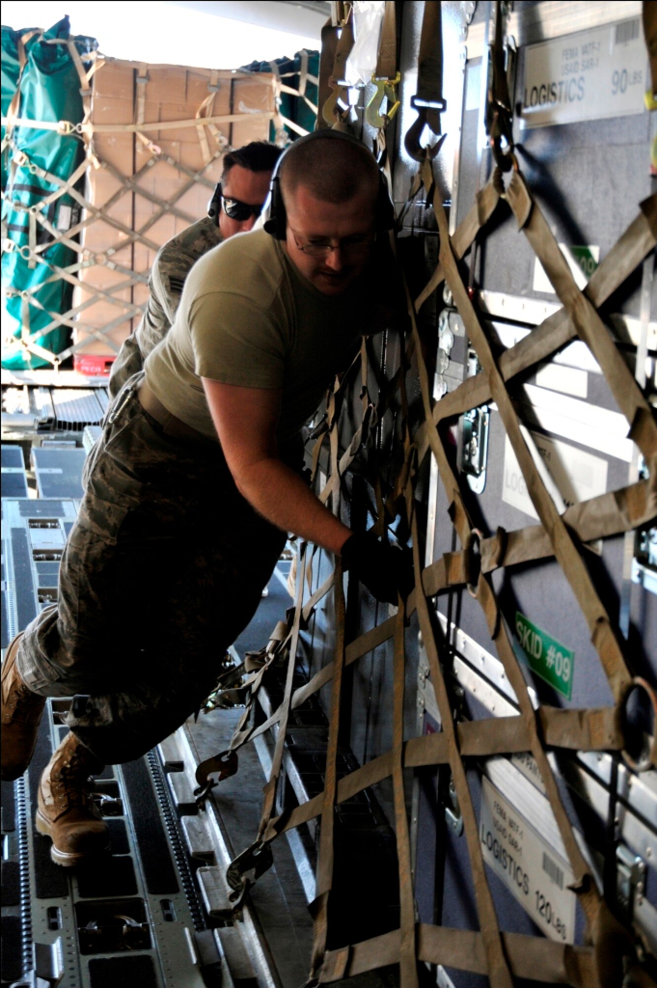 Airmen from the 89th Aerial Port Squadron load pallets onto a C-17 Globemaster III on March 12, 2011, at Joint Base Andrews, Md. Air transportation Airmen from the 89th APS created 14 pallets of technical search and rescue gear, to include inflatable swift-water rescue boats, generators, trench rescue and cutting equipment. The gear is being transported by C-17 to more than 80 Fairfax County Urban Search and Rescue technicians, to provide assistance in the rescue effort after an earthquake and tsunami hit Japan on March 11, 2011. (U.S. Air Force Photo/Senior Airman Perry Aston) 