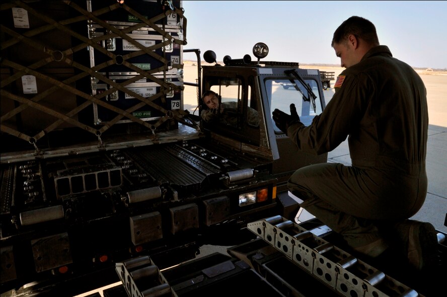 Staff Sgt. Nick Kolesnikov, 3rd Airlift Squadron loadmaster, marshals a loader carrying rescue equipment to the ramp of a C-17 Globemaster III on March 12. 2011, at Joint Base Andrews, Md. Air transportation Airmen from the 89th Aerial Port Squadron at Joint Base Andrews created 14 pallets of technical search and rescue gear, to include inflatable swift-water rescue boats, generators, trench rescue and cutting equipment. The gear is being transported by C-17 to more than 80 Fairfax County Urban Search and Rescue technicians, to provide assistance in the rescue effort after an earthquake and tsunami hit Japan on March 11, 2011. (U.S. Air Force Photo/Senior Airman Perry Aston) 