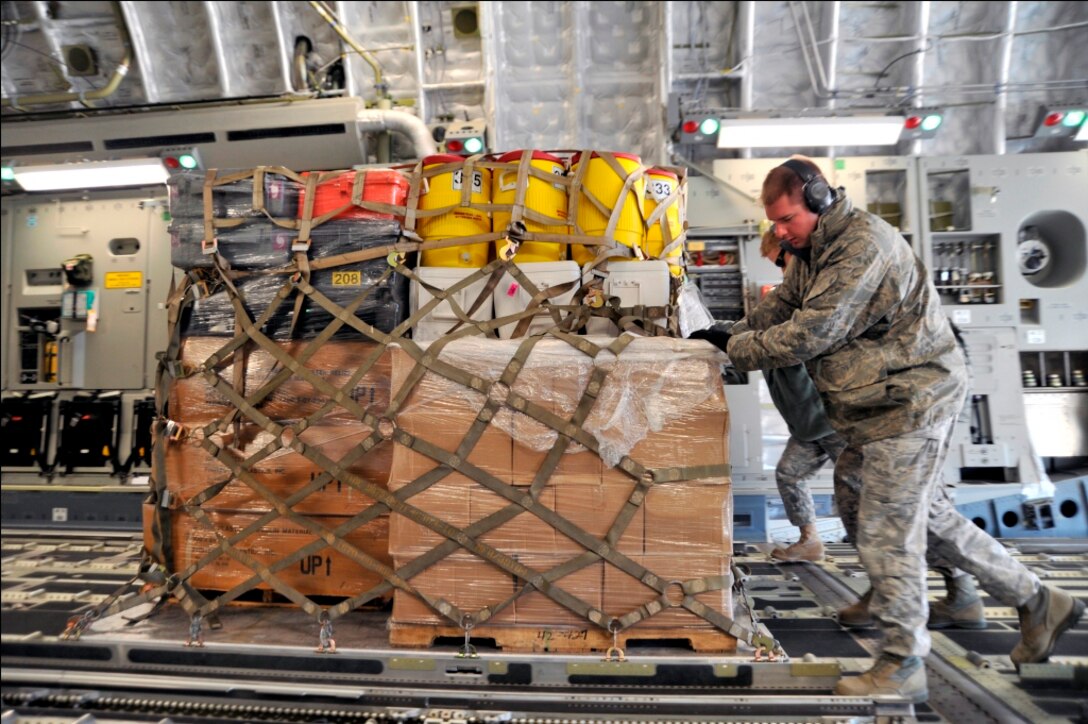 Airmen from the 89th Aerial Port Squadron load pallets onto a C-17 Globemaster III on March 12, 2011, at Joint Base Andrews, Md. Air transportation Airmen from the 89th APS created 14 pallets of technical search and rescue gear, to include inflatable swift-water rescue boats, generators, trench rescue and cutting equipment. The gear is being transported by C-17 to more than 80 Fairfax County Urban Search and Rescue technicians, to provide assistance in the rescue effort after an earthquake and tsunami hit japan on March 11. (U.S. Air Force Photo/Senior Airman Perry Aston) 