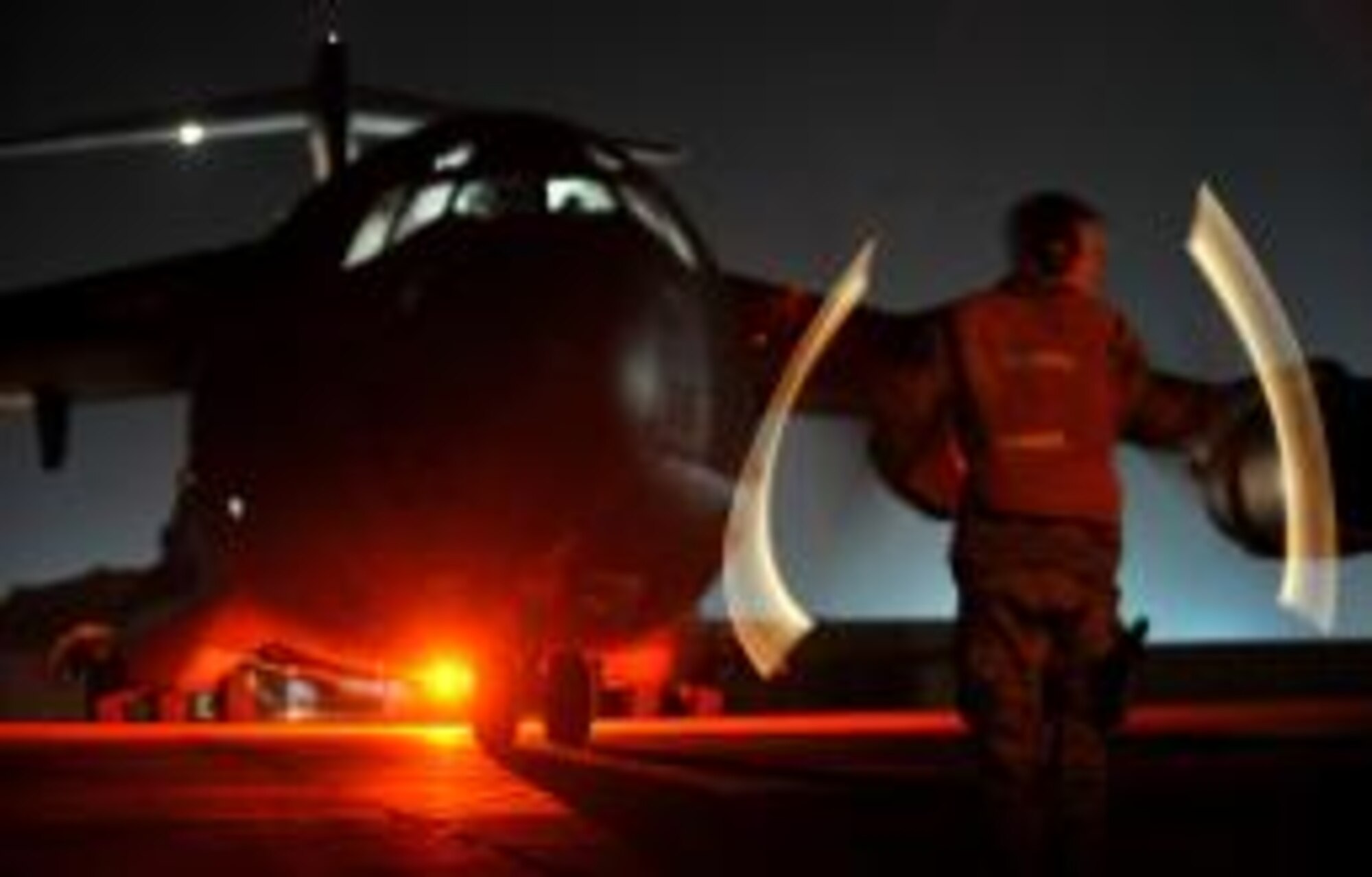 Staff Sgt. Korey Cornelis directs a C-17 airplane to its designated location on the flight line, Feb. 24, at Ali Air Base, Iraq.
