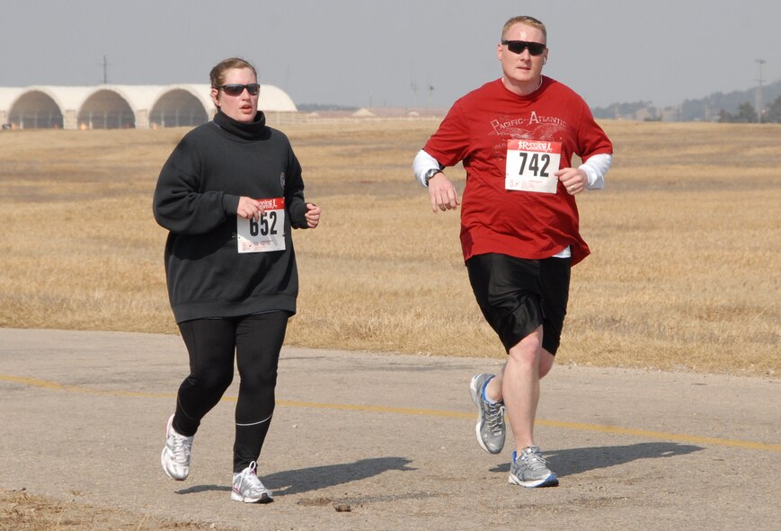 KUNSAN AIR BASE, Republic of Korea -- Master Sgt. Carolyn Urdiales, 8th Fighter Wing commander's knowlege operations management superintendent, and her running partner Master Sgt. Sonny Cohrs, 8th FW public affairs superintendent, run along Perimeter Road during the Kunsan half-marathon March 11. The pair completed the event in three hours and five minutes. (U.S. Air Force/Staff Sgt. Amanda Savannah)